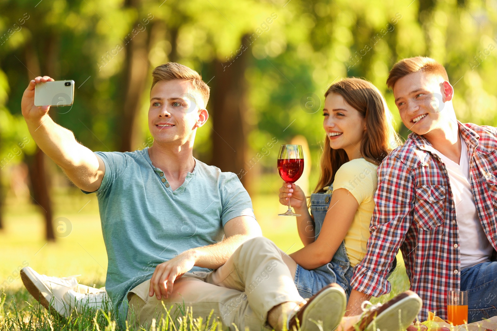 Photo of Young people enjoying picnic in park on summer day