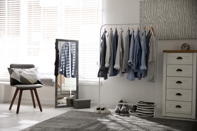 Photo of Dressing room interior with clothing rack and mirror