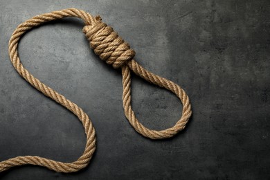 Photo of Rope noose with knot on grey table, top view. Space for text
