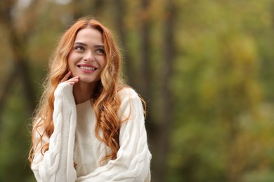 Photo of Autumn vibes. Portrait of smiling woman outdoors. Space for text