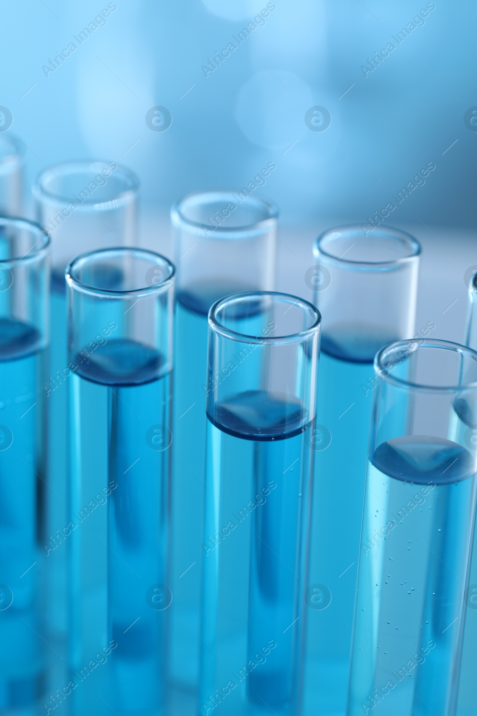 Photo of Test tubes with light blue liquid in laboratory, closeup