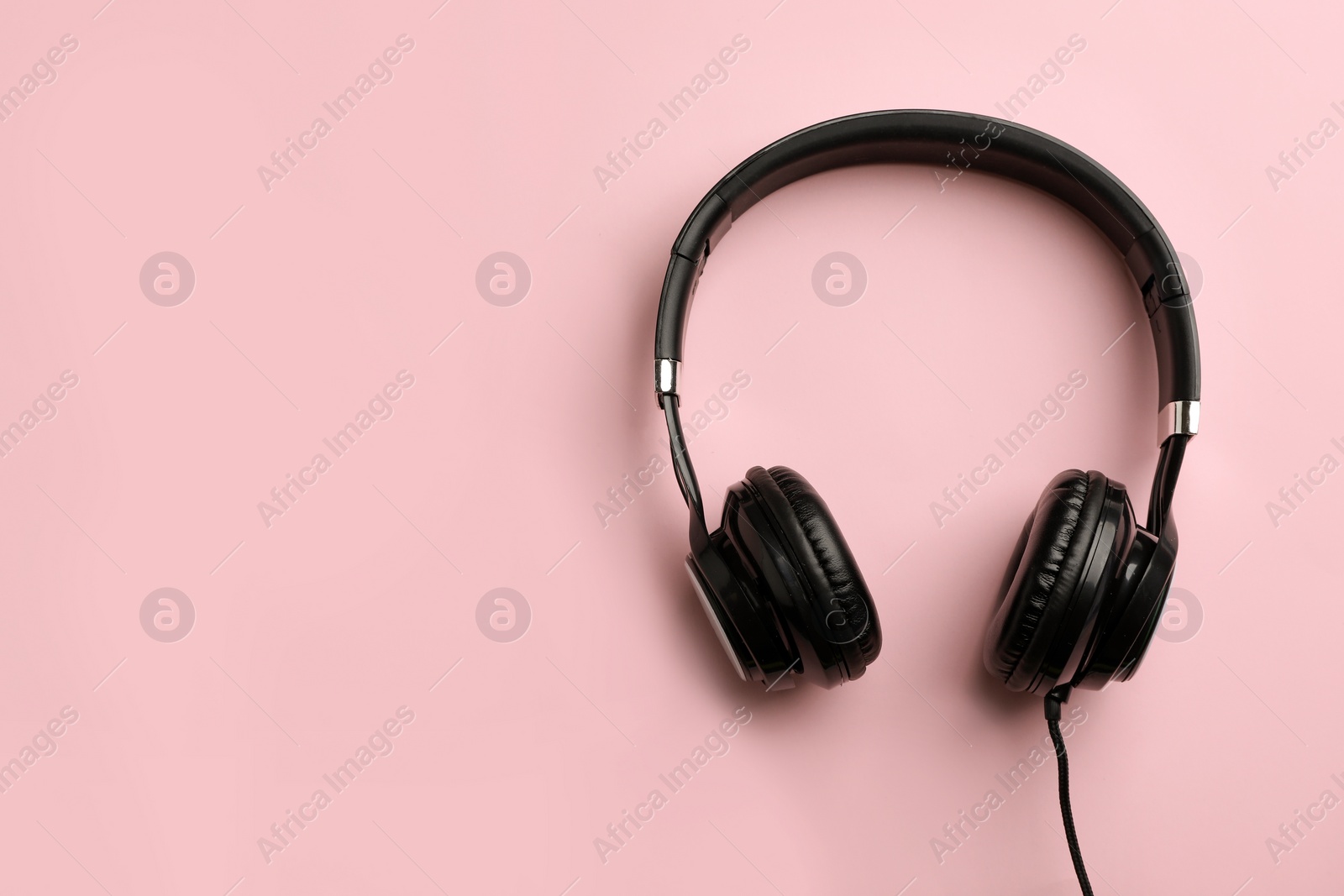 Photo of Stylish headphones on color background, top view. Space for text