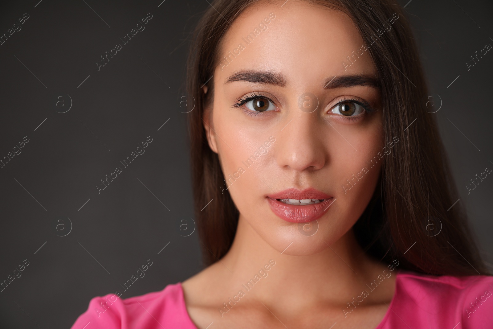 Photo of Portrait of beautiful young woman on dark grey background, closeup