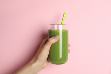 Photo of Woman holding glass of tasty smoothie against pink background, closeup