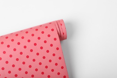 Photo of Roll of polka dot wrapping paper on white background, top view. Space for text
