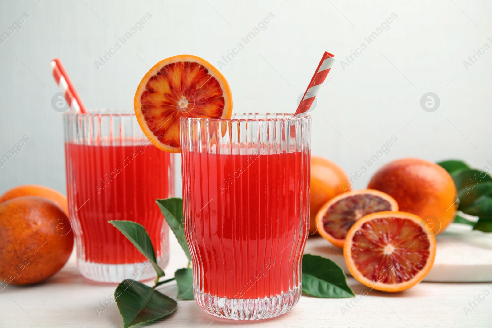 Photo of Tasty sicilian orange juice and fruits on white wooden table