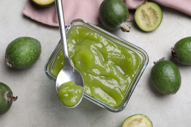 Feijoa jam and fresh fruits on grey table, flat lay