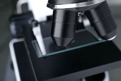 Photo of Modern medical microscope with glass slide, closeup