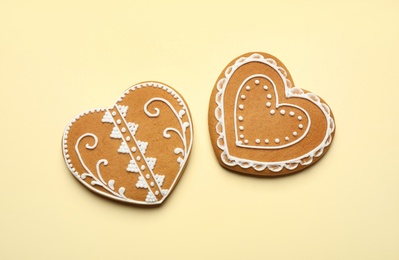 Tasty heart shaped gingerbread cookies on yellow background, flat lay