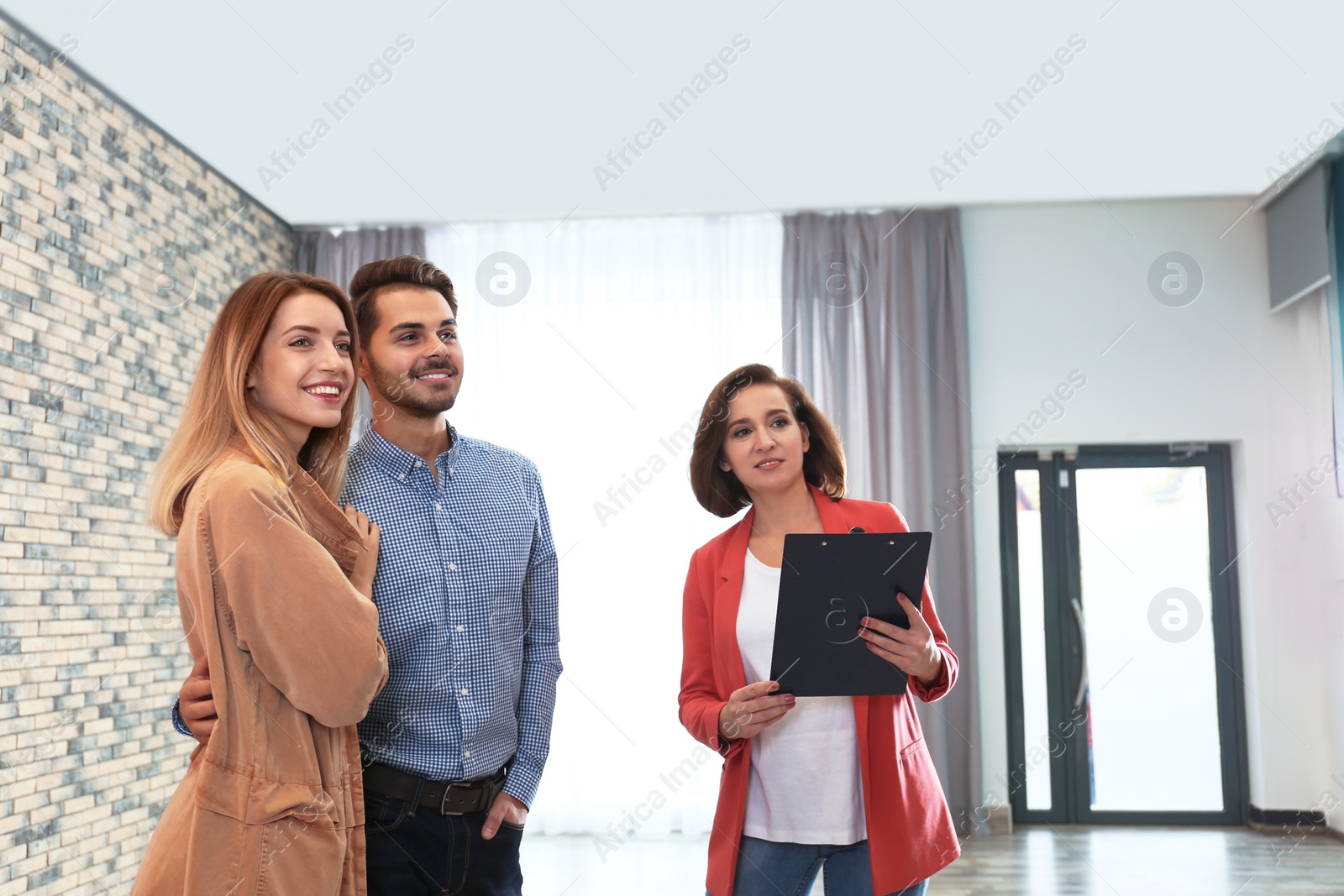Photo of Real estate agent showing new apartment to young couple