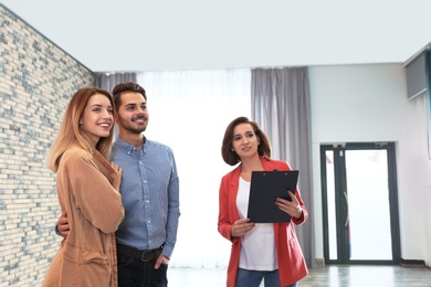 Real estate agent showing new apartment to young couple