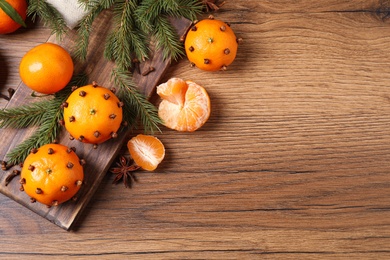 Photo of Delicious fresh tangerines and Christmas decor on wooden table, flat lay. Space for text