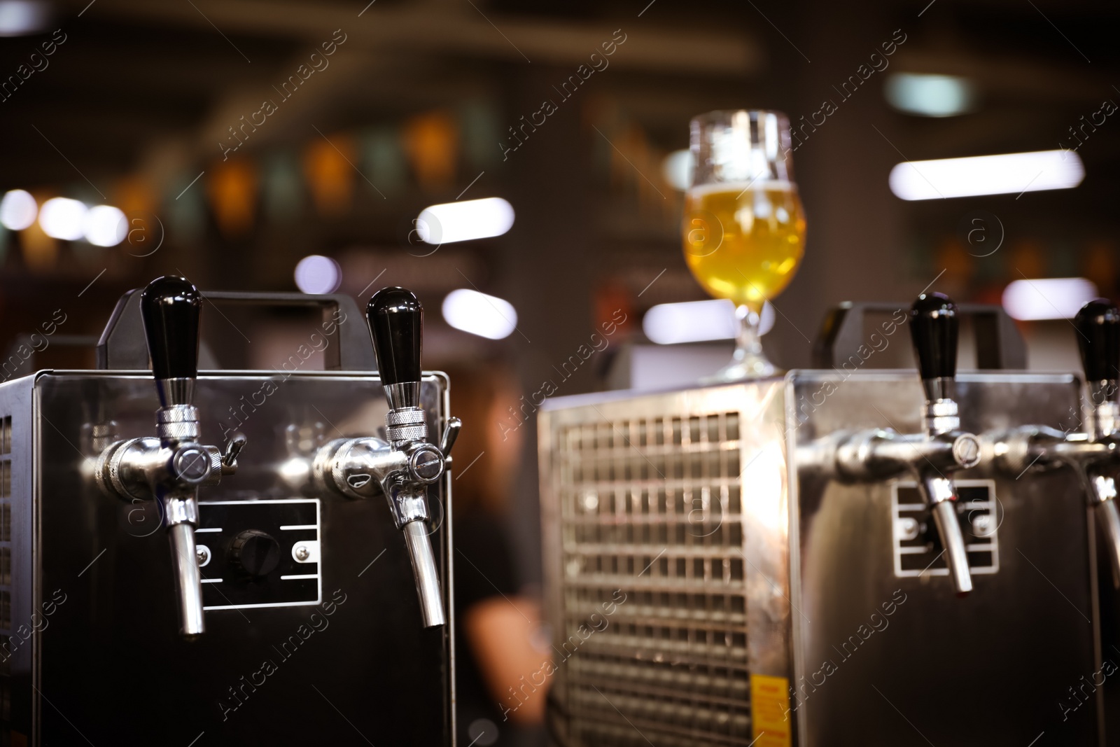 Photo of Glass of refreshing beer on cooling machine in pub