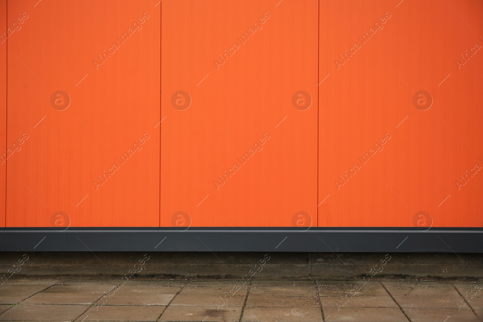 Photo of Beautiful orange wall and stone pavement outdoors