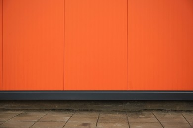 Photo of Beautiful orange wall and stone pavement outdoors