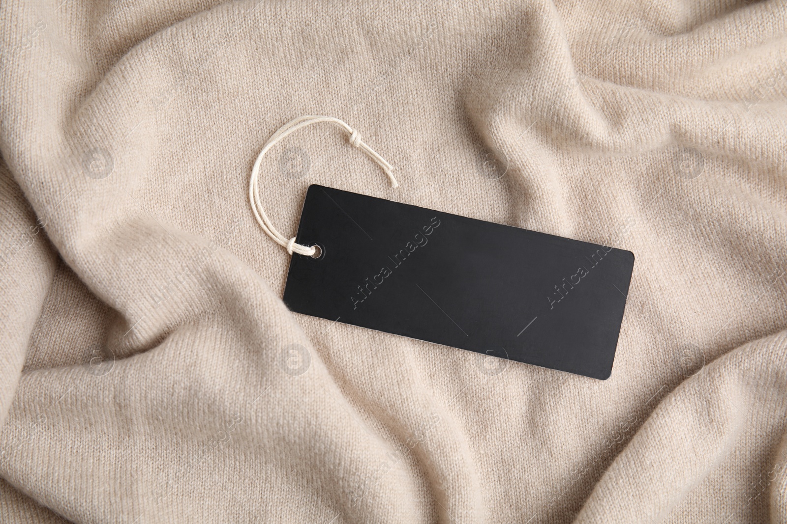 Photo of Warm beige cashmere sweater with tag, closeup