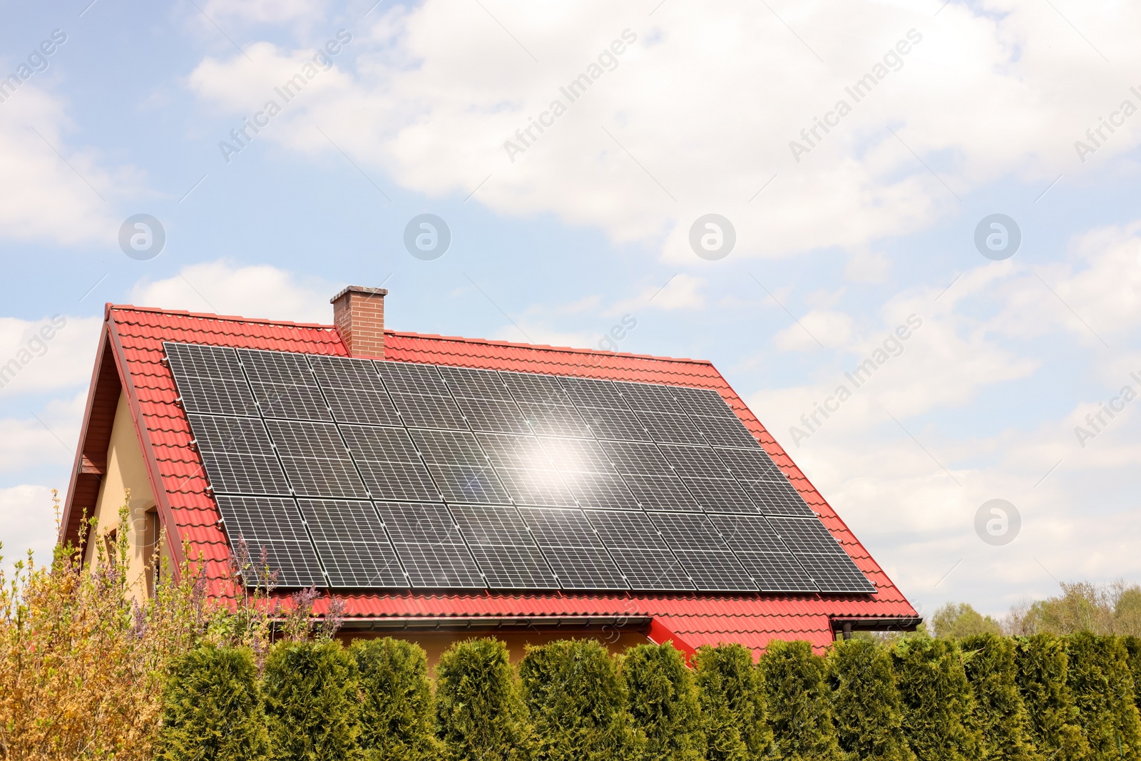 Photo of House with installed solar panels on roof. Alternative energy