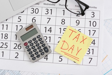 Photo of Flat lay composition with calendar, calculator and glasses on table. Tax day