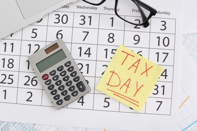 Flat lay composition with calendar, calculator and glasses on table. Tax day