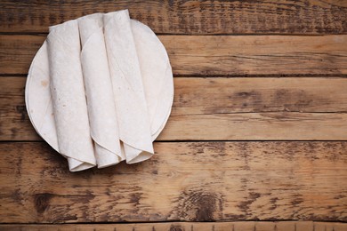 Delicious rolled Armenian lavash on wooden table, top view. Space for text