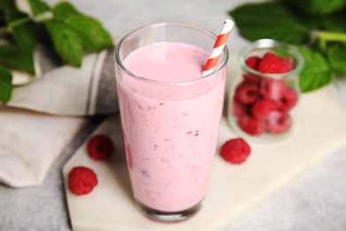 Photo of Glass of tasty raspberry smoothie on light table