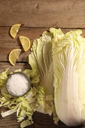 Fresh Chinese cabbage, salt and lemon on wooden table, flat lay