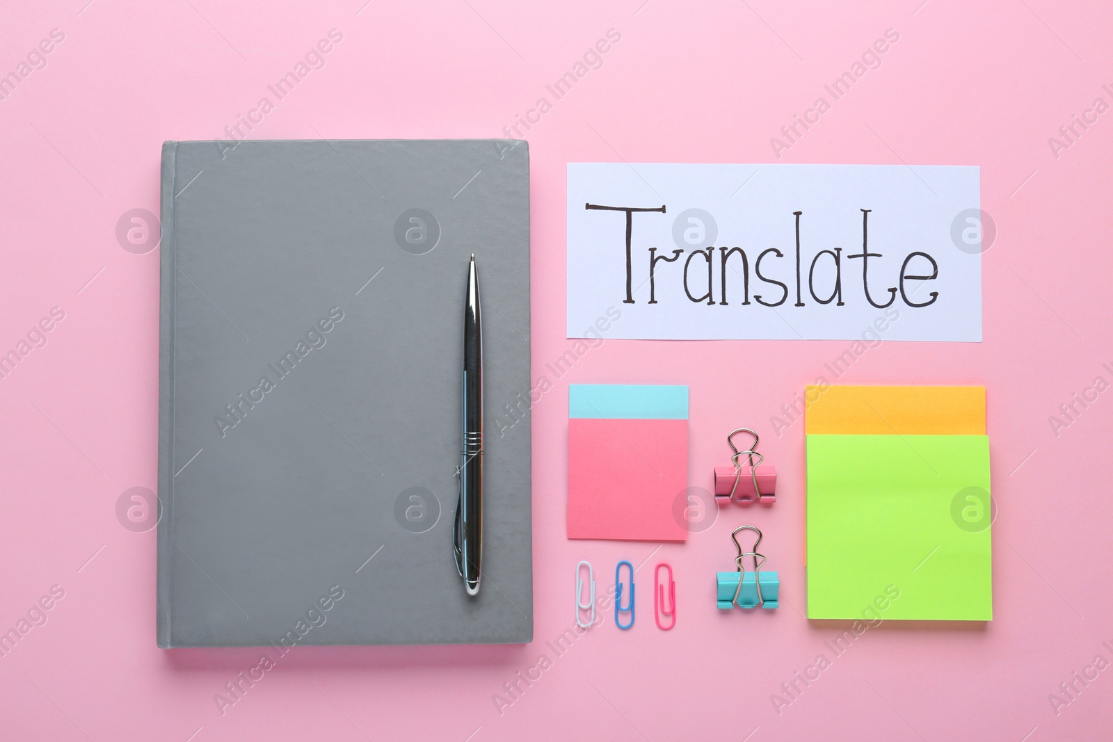 Photo of Paper with word Translate and stationery on pink background, flat lay