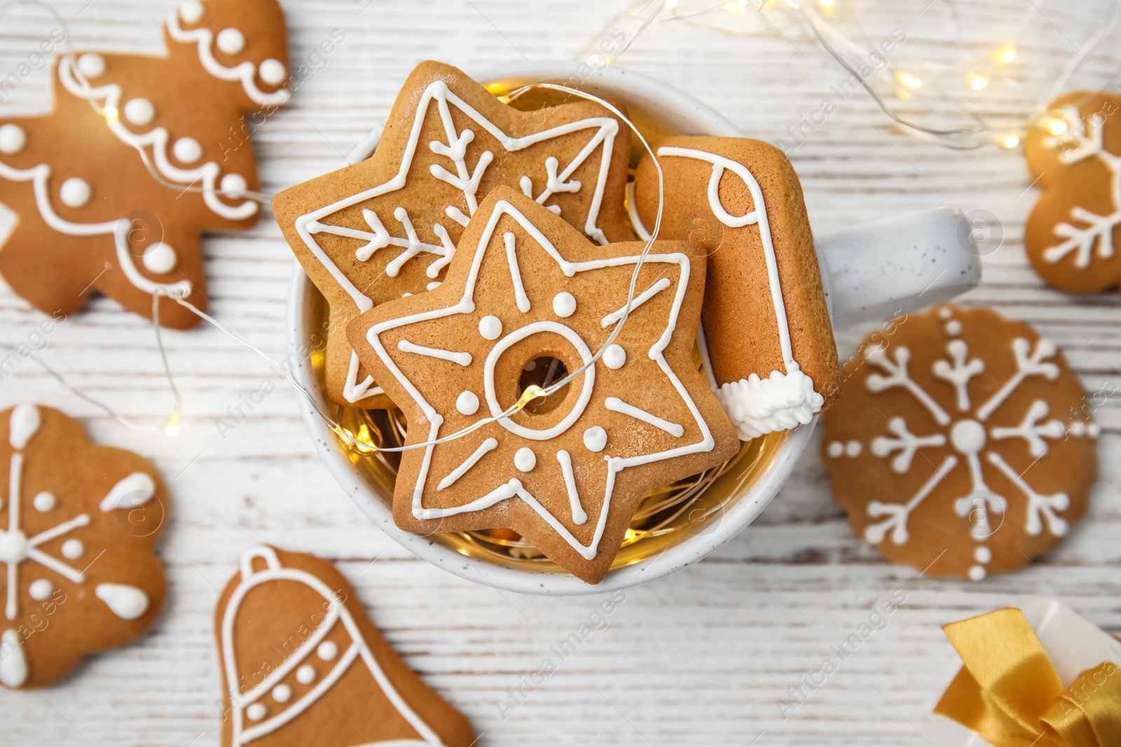 Photo of Cup with tasty homemade Christmas cookies on wooden table, top view