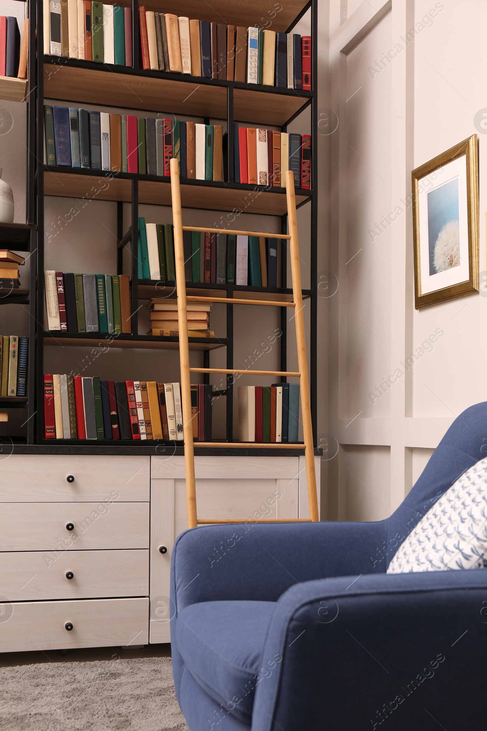 Photo of Home library interior with wooden ladder and collection of books on shelves