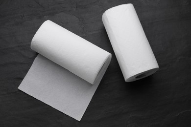 Photo of Rolls of paper towels on black table, flat lay