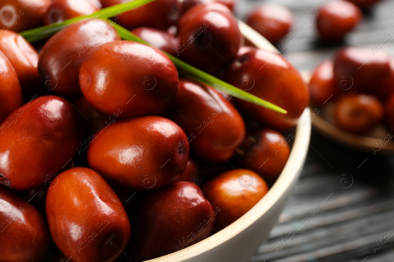 Photo of Palm oil fruits in bowl on table, closeup