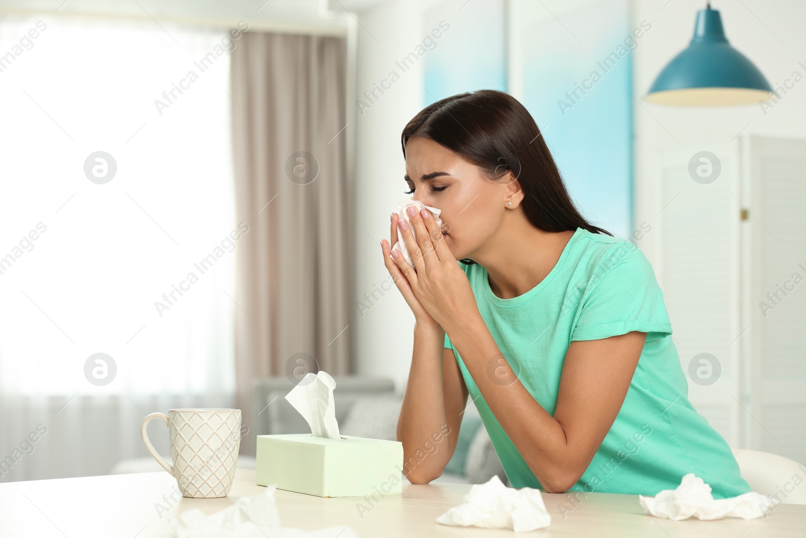 Photo of Young woman suffering from allergy at home