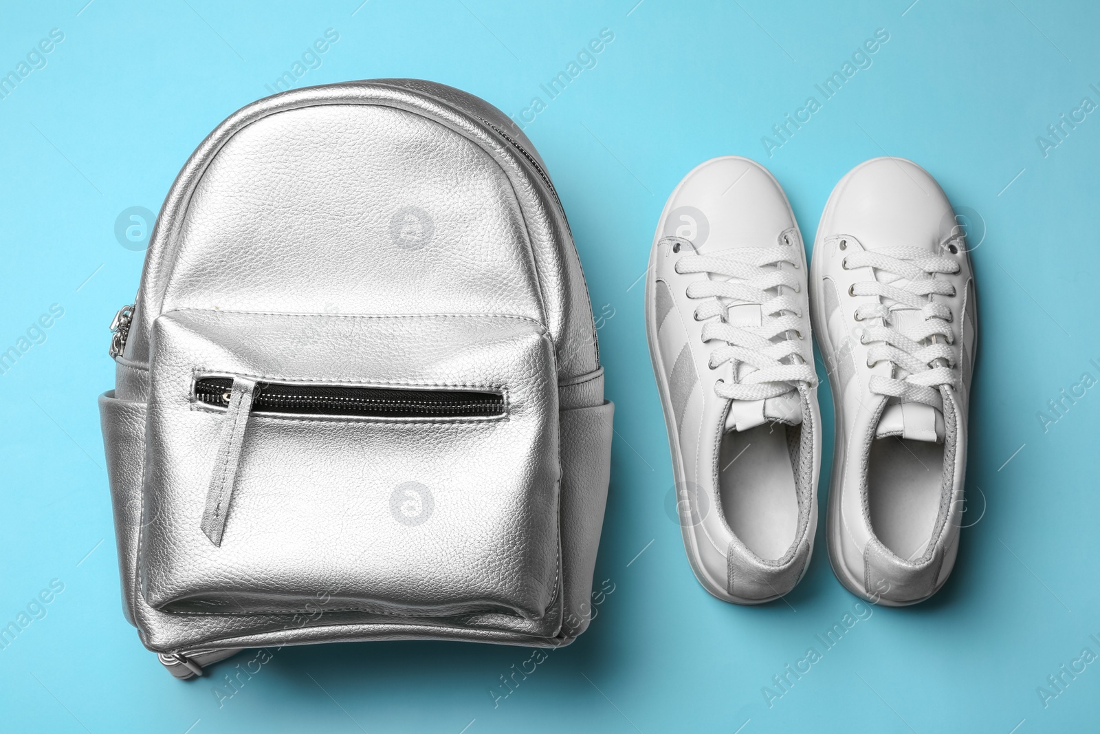 Photo of Flat lay composition of stylish shoes and backpack on color background