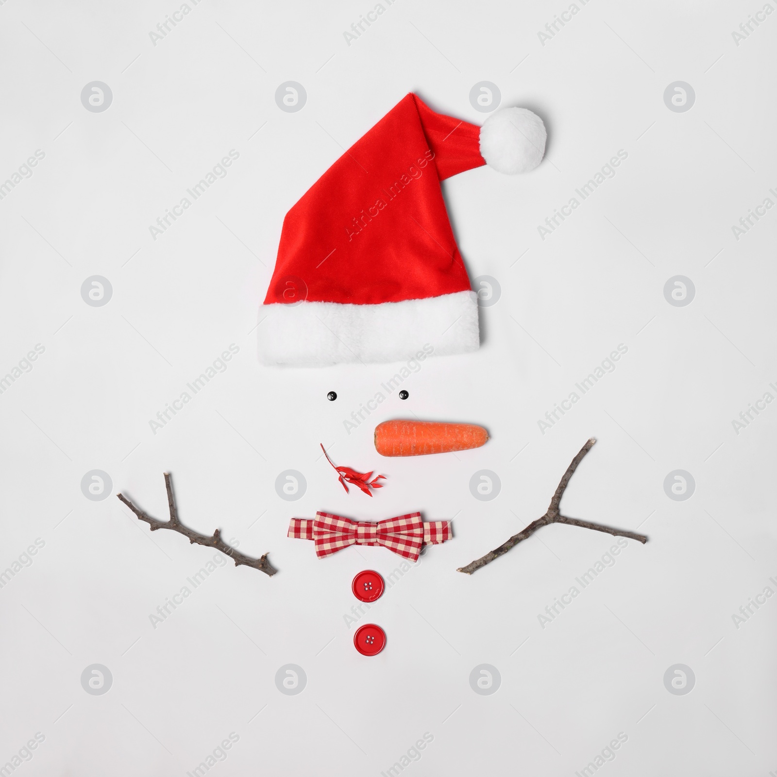 Photo of Creative snowman shape made of Santa hat and different items on white background, flat lay