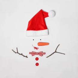 Creative snowman shape made of Santa hat and different items on white background, flat lay