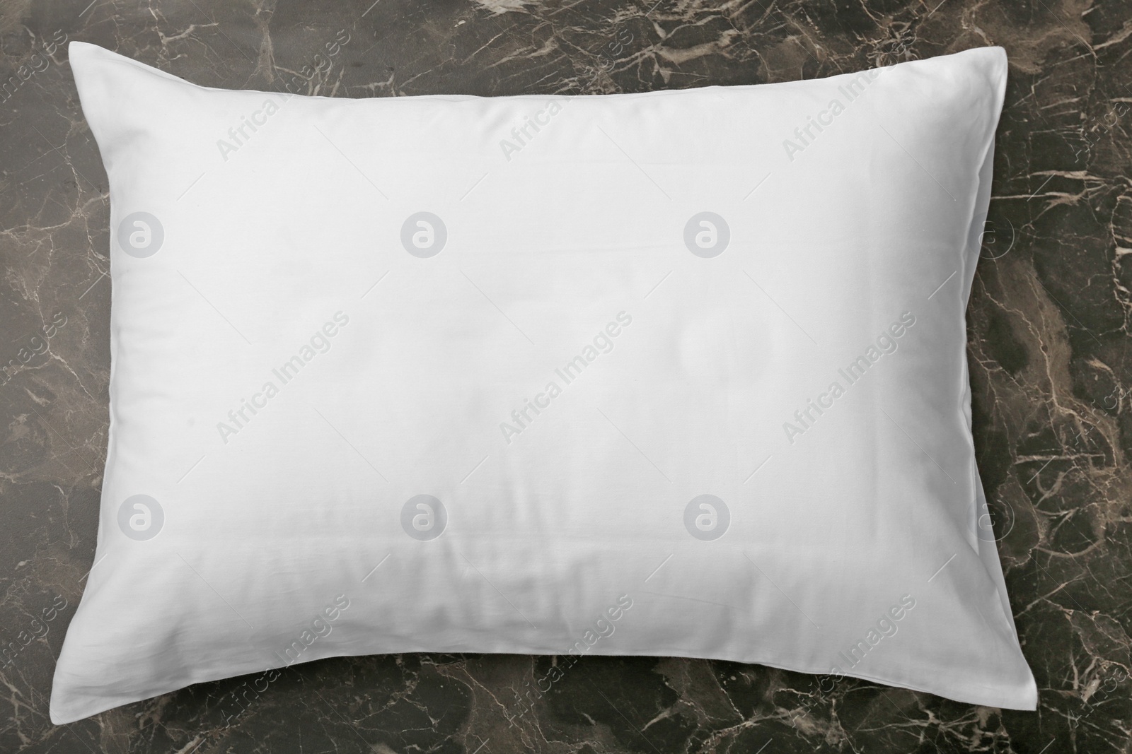 Photo of Soft bed pillow on dark background, top view