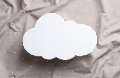 Photo of Cloud shaped child's night lamp on beige fabric, top view