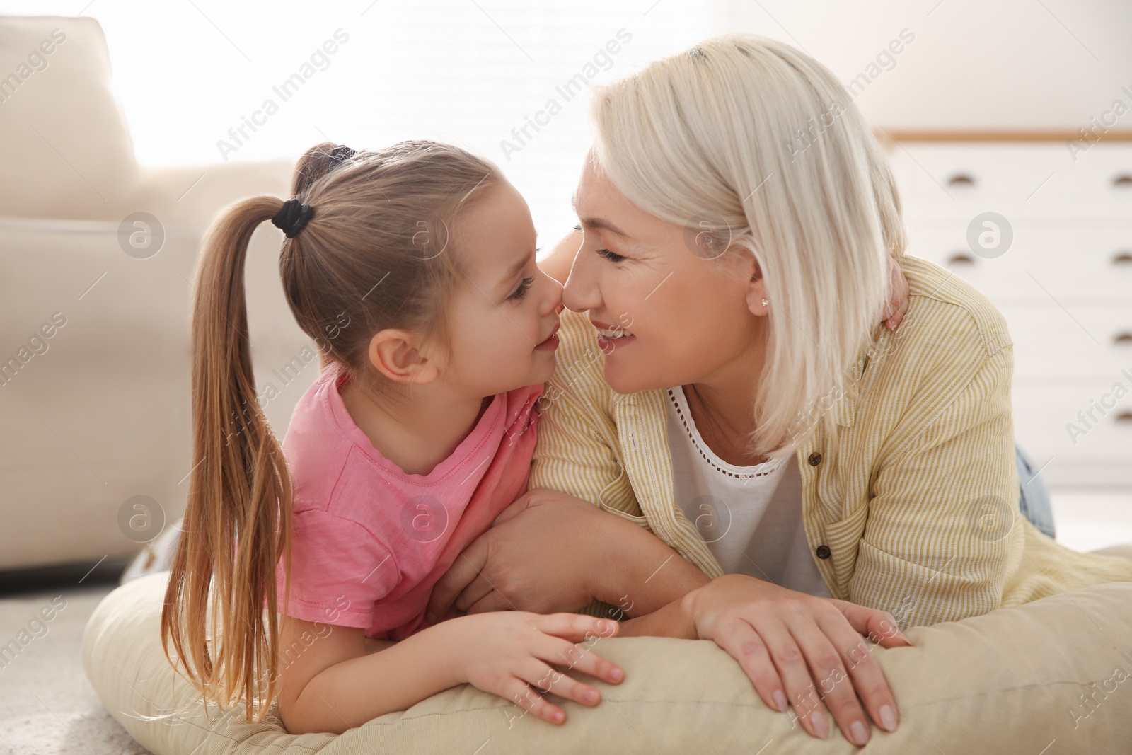 Photo of Mature woman with her little granddaughter at home