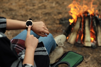 Photo of Woman using stylish smart watch outdoors, closeup