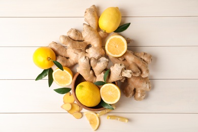 Photo of Fresh lemons and ginger on white wooden table, flat lay