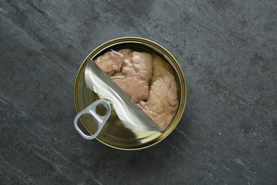 Open tin can of tasty cod liver on black table, top view
