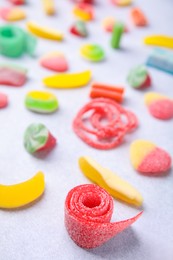 Photo of Many tasty colorful jelly candies on white table, closeup