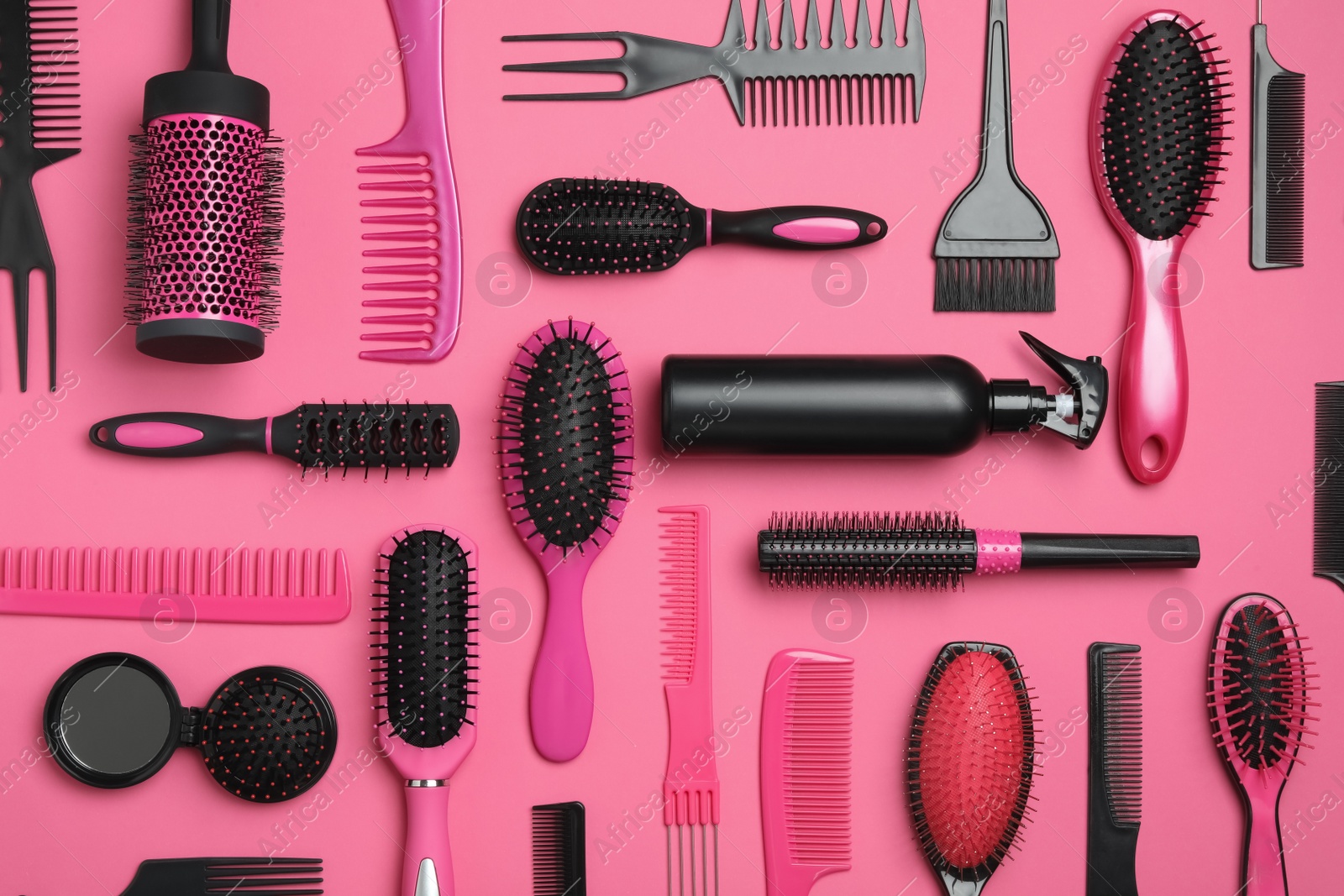 Photo of Flat lay composition with modern hair combs and brushes on pink background