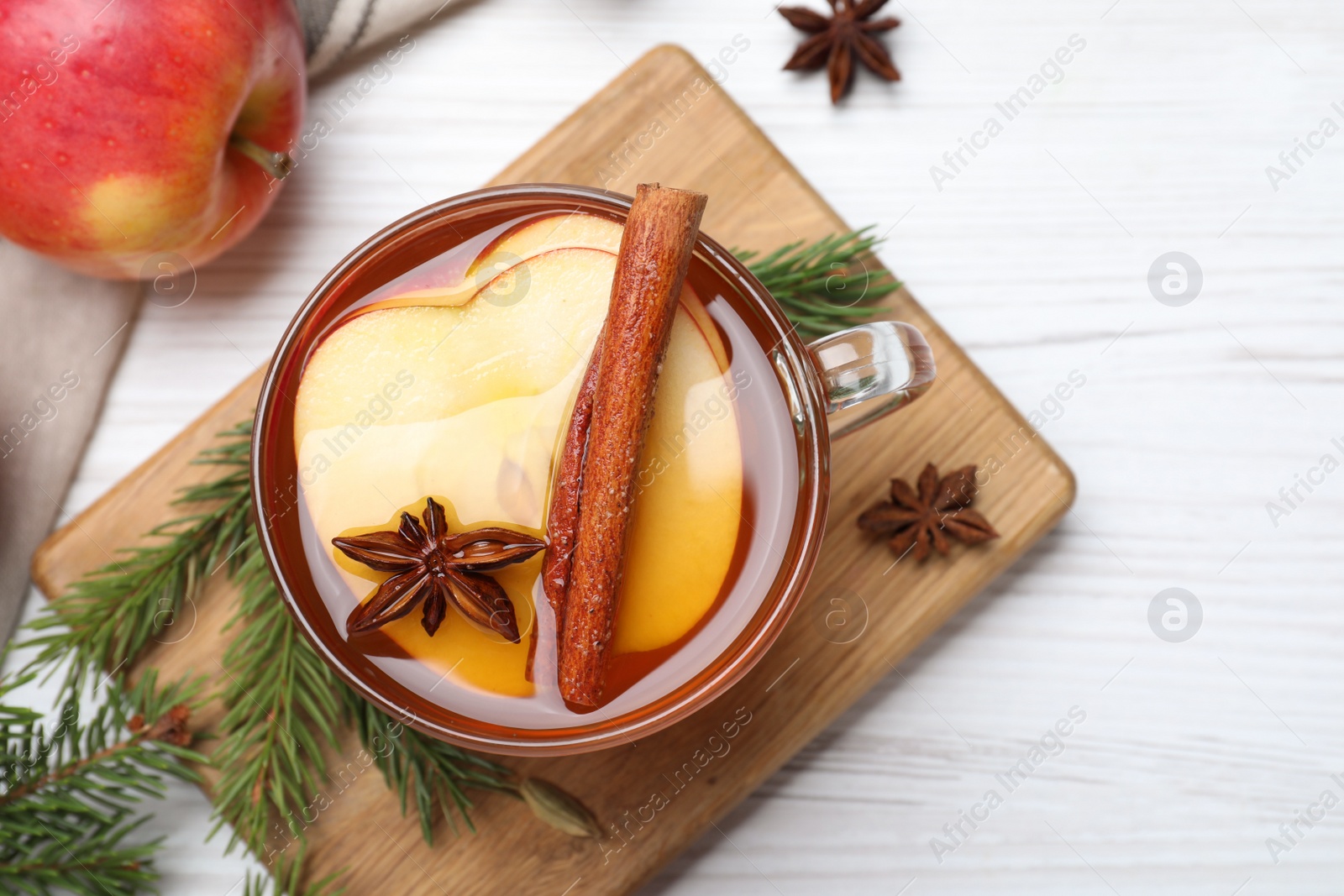 Photo of Aromatic hot mulled cider on white wooden table, flat lay