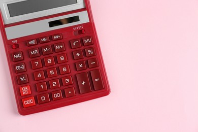 Photo of Red calculator on pink background, top view. Space for text