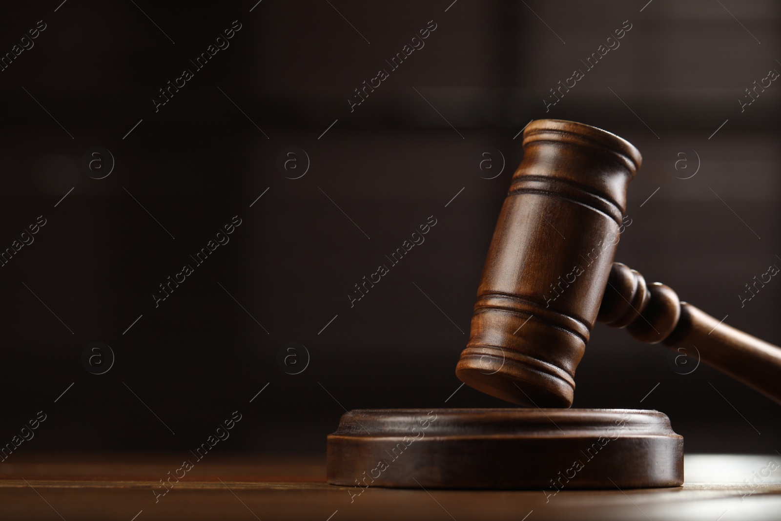Photo of Wooden gavel on table against blurred background, closeup. Space for text