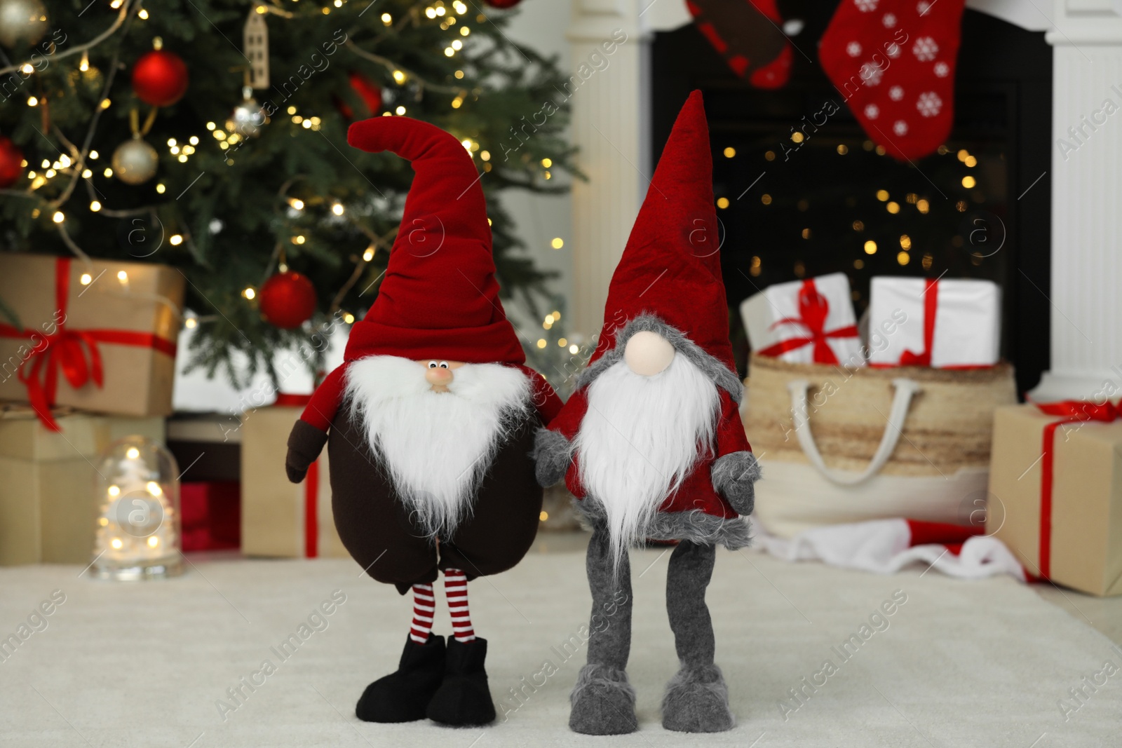 Photo of Funny Christmas gnomes on floor in decorated room