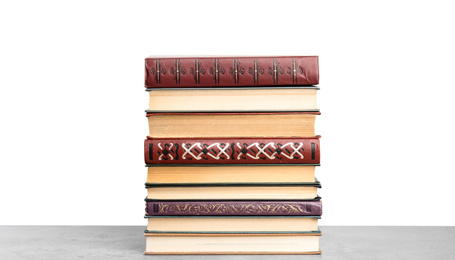 Stack of old vintage books on stone table against white background