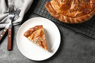 Piece of tasty homemade pie with filling served on grey table, flat lay