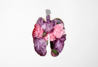 Photo of No smoking concept. Top view of flowers through burned lungs shaped paper